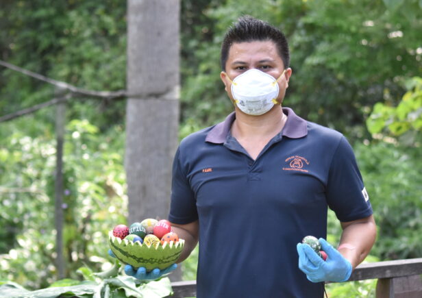 Team member holding Easter eggs for the orangutans