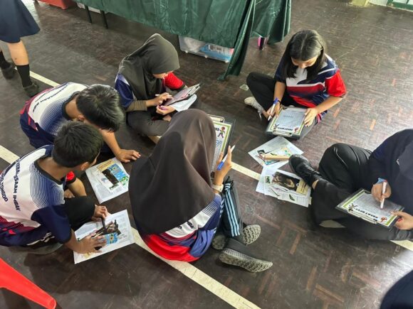 A group of children sat working on a crossword puzzle about orangutans at the Heart of Borneo event