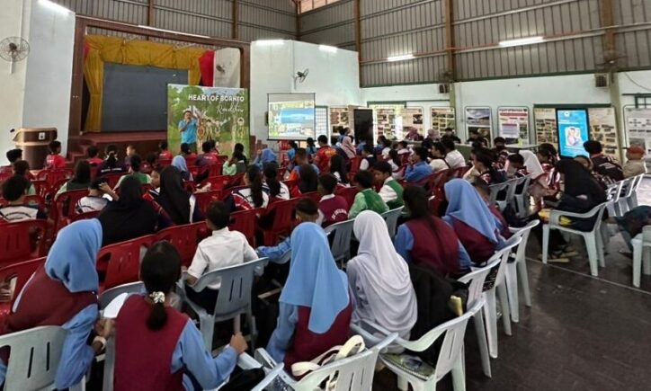 Children sat down in row looking forward to a man from HOB giving a presentation
