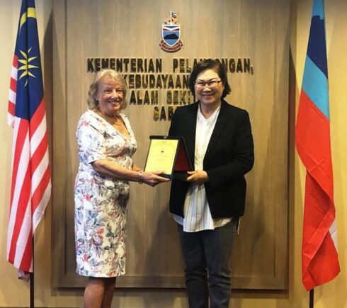 Yb Christina Liew and Susan Sheward standing side by side whilst holding a plaque.