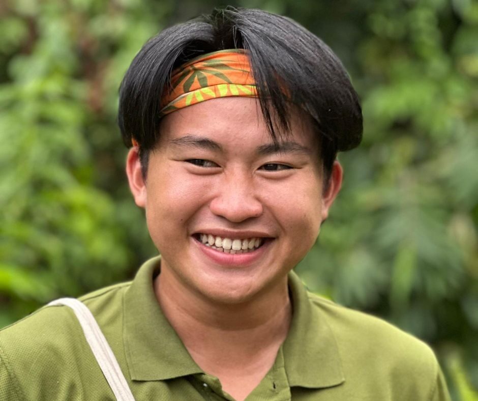Man wearing a bright orange headband with the Orangutan Appeal UK logo across it and green leaf design.