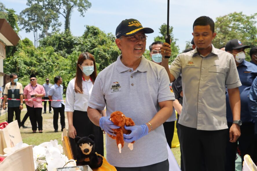 The king of Malaysia holding an orangutan soft toy at Sepilok.