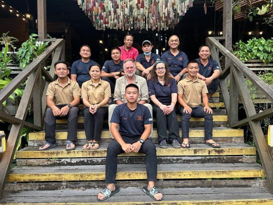 Orangutan Appeal UK staff sit on stairs outside Sepilok Orangutan Rehabilitation Centre.