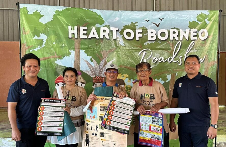 5 people standing in front of a poster that reads 'Heart of Borneo'